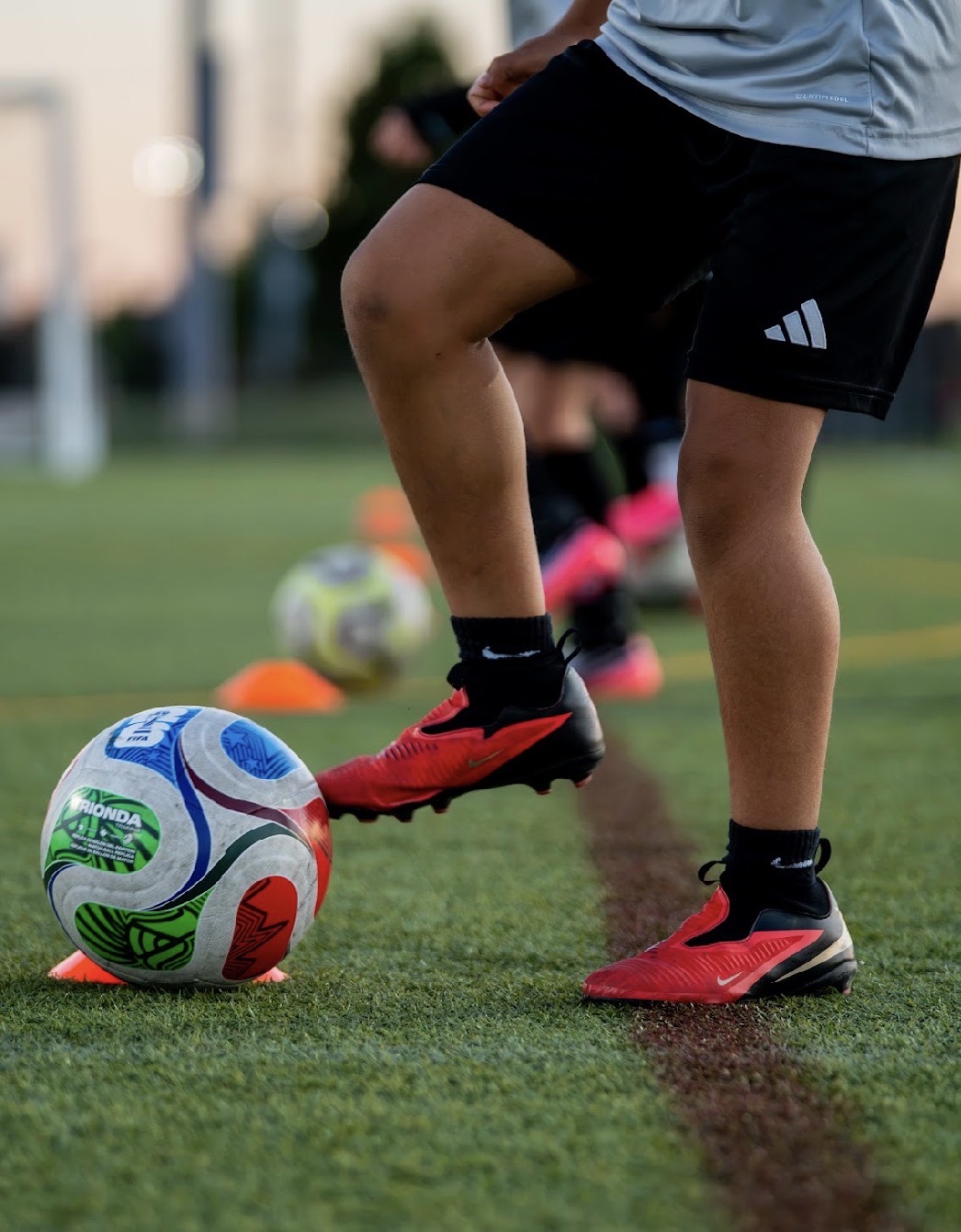 Coach demonstrating soccer footwork over the ball